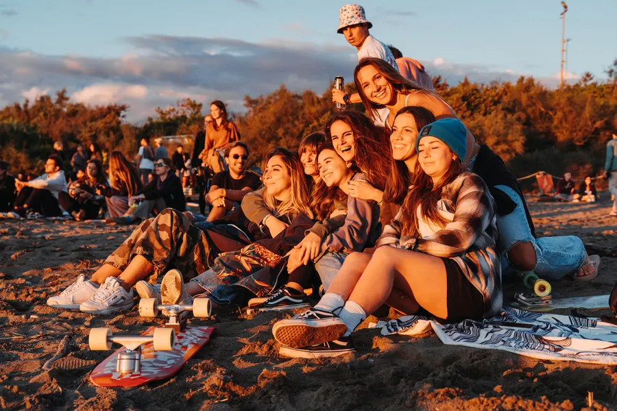 Un gruppo di amici al tramonto sulla spiaggia del MeetUp